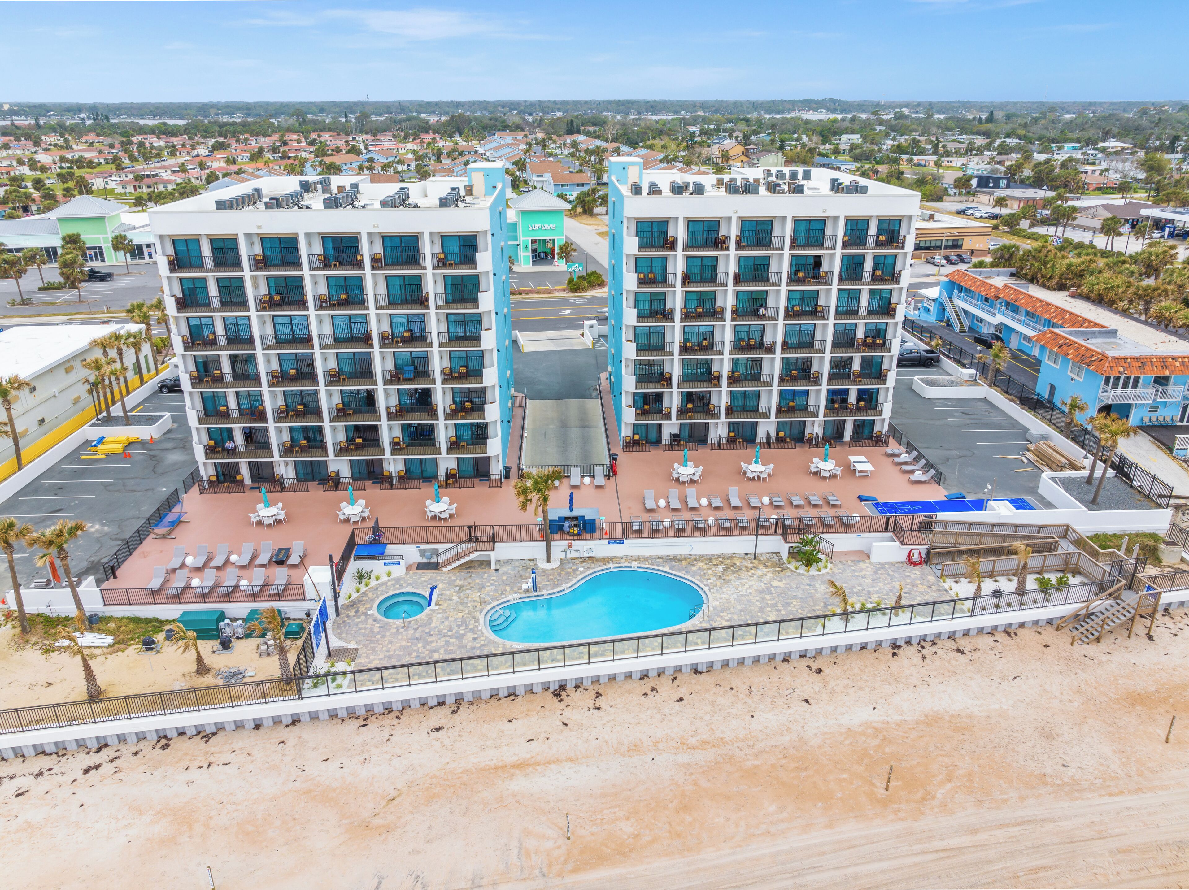 A hotel with multiple floors, outdoor pool, and sun loungers.