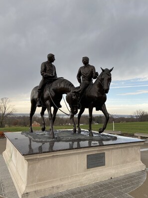 A bronze equestrian statue on a rectangular pedestal with a plaque.