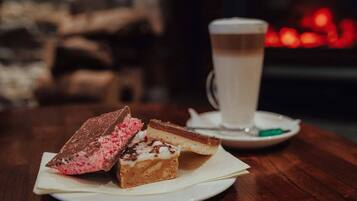 Una bandeja de postres con dos porciones de pastel y una taza de café sobre una mesa de madera.