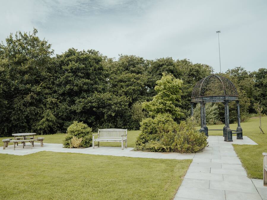 A park with a gazebo, benches, and a picnic table.