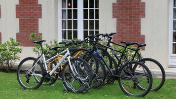 Bicicletas estacionadas frente a un edificio de fachada de ladrillo y grandes ventanales.