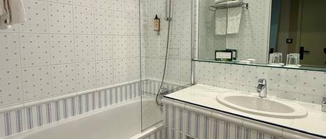 A bathroom with a glass-enclosed shower, a large mirror, and a striped vanity.