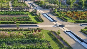 A well-maintained garden with pathways, a greenhouse, and various plant beds. - Chateau Colbert (Maulevrier)