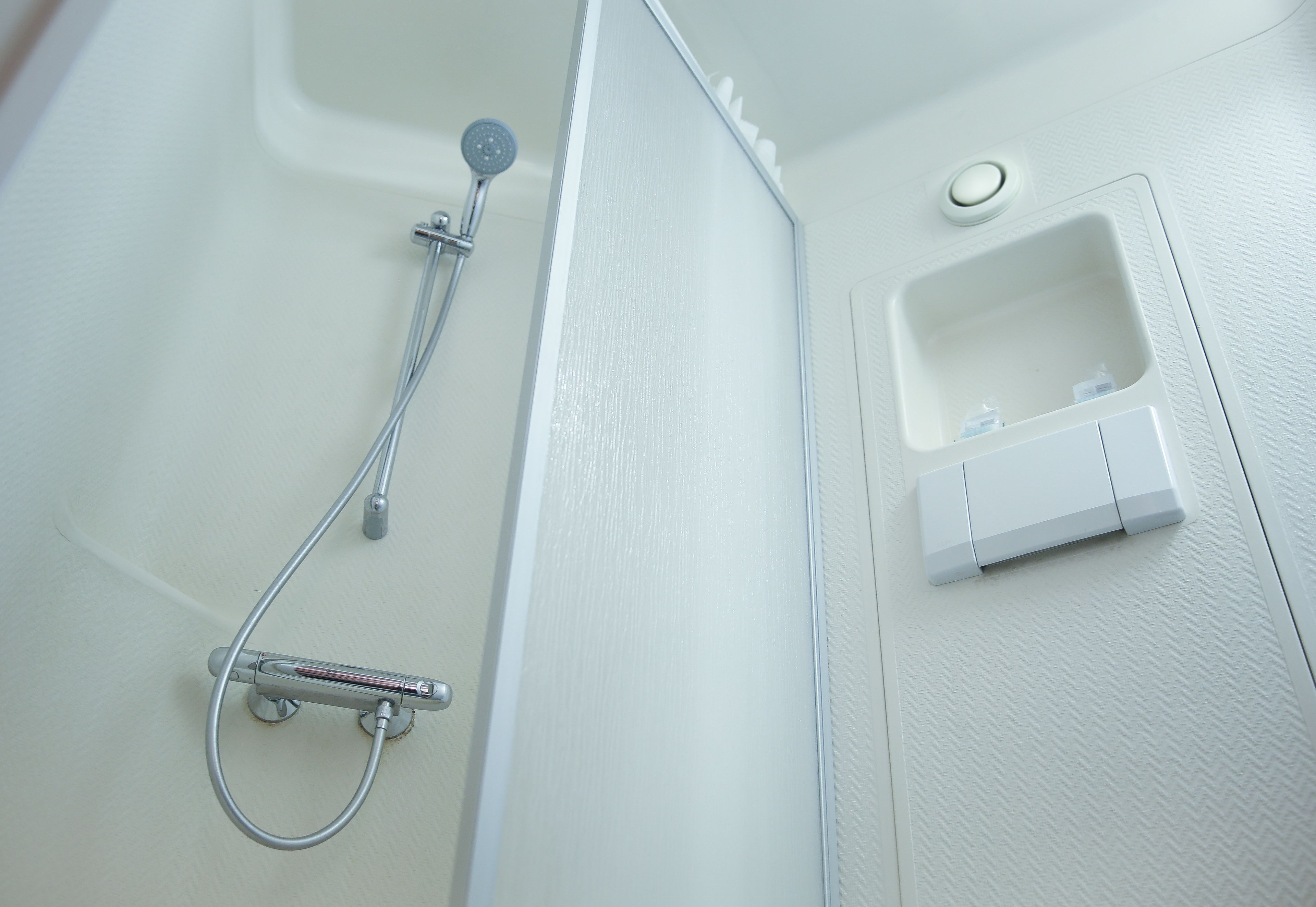 A bathroom with a shower, a sink, and a toilet.