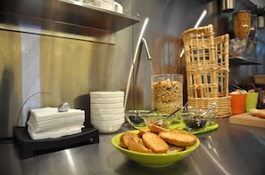 A buffet setup with various food items and serving utensils. - BHôtel De Caen (Mondeville)