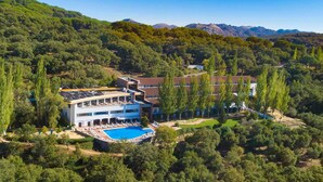 A resort with a pool, multiple buildings, and a mountainous backdrop.