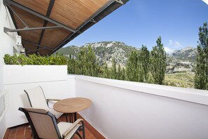 A balcony with a table and chairs, overlooking a mountainous landscape. - Hotel Fuerte Grazalema (Grazalema)