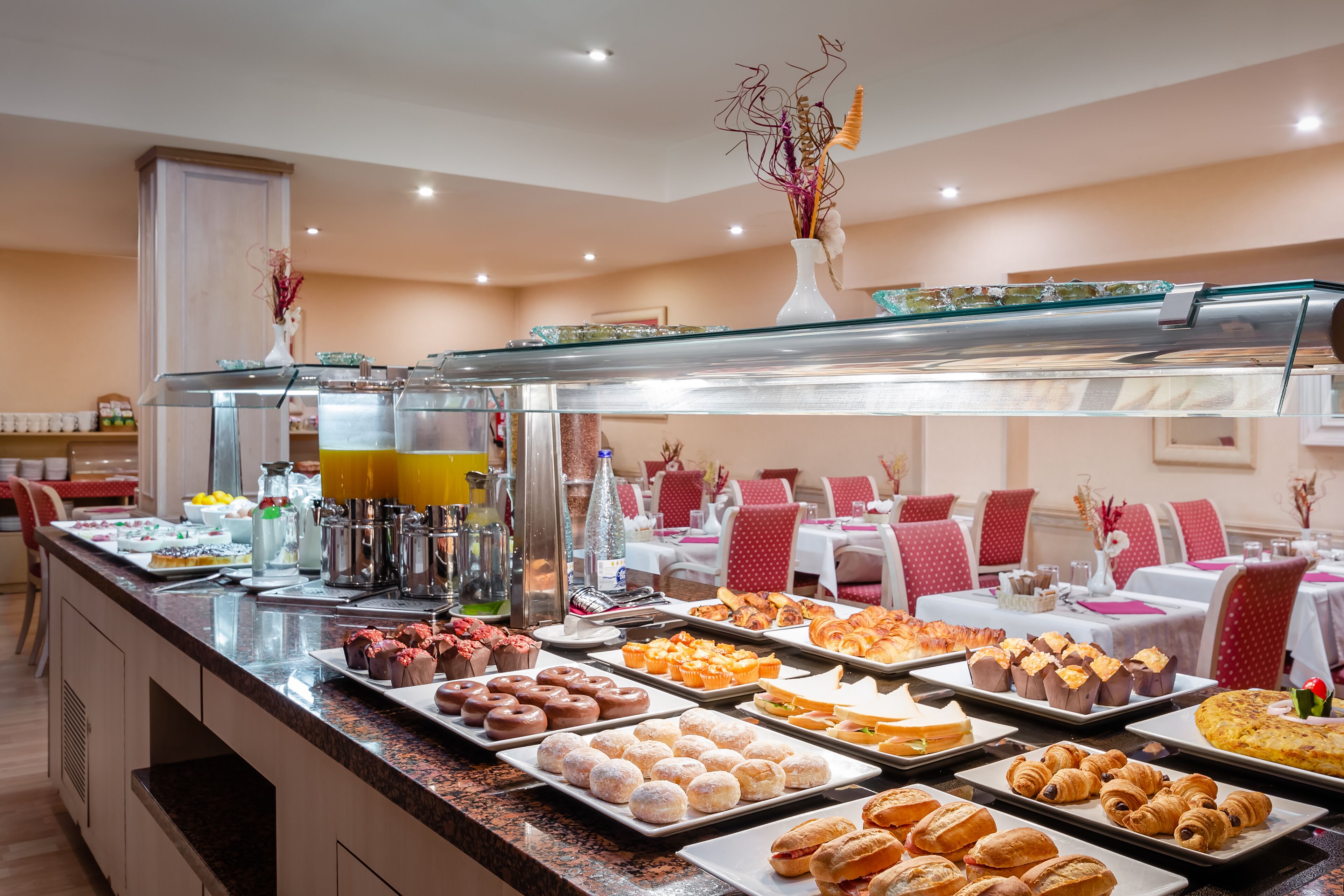 Un buffet proposant une variété de pâtisseries et de boissons.