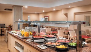 A buffet with various food options, a glass display case, and seating areas. - Sunotel Aston (Barcelona)