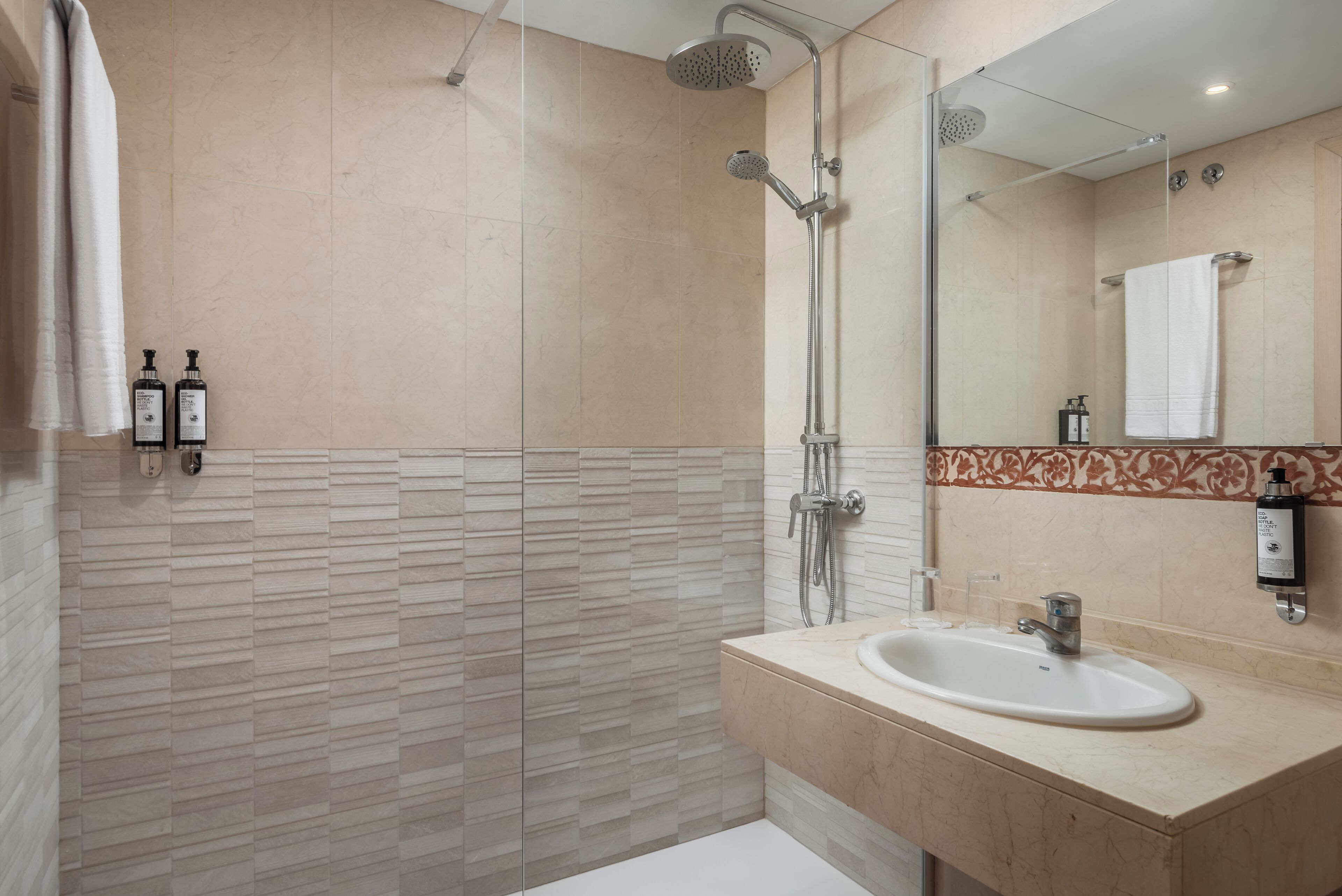 Une salle de bain moderne avec une douche, un lavabo et un miroir.