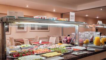 Buffet amb diverses fruites, verdures i plats preparats.