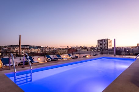 Una piscina al aire libre, sillones reclinables de piscina