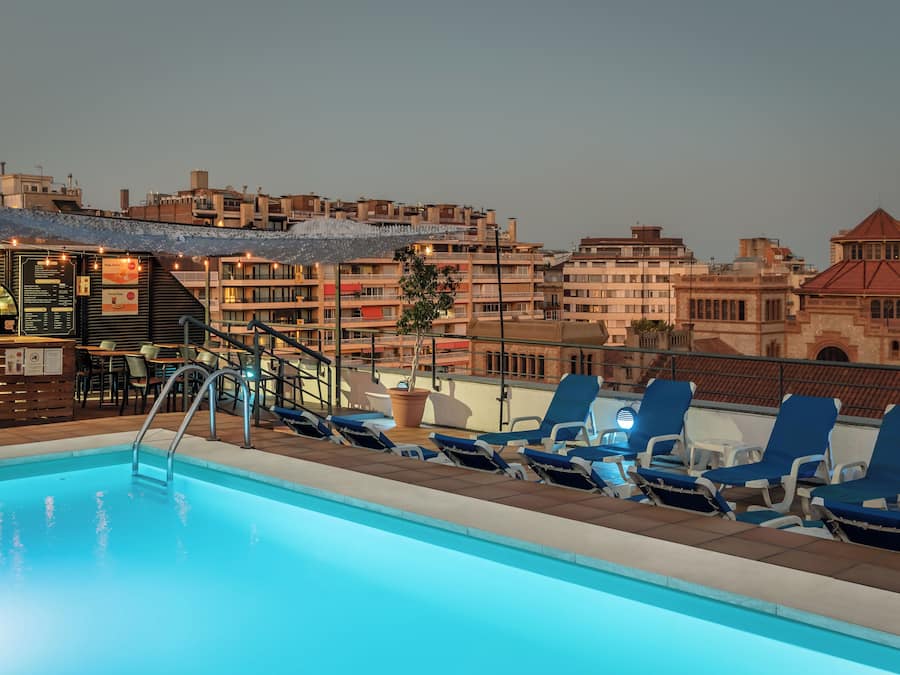 Una piscina al aire libre, sillones reclinables de piscina