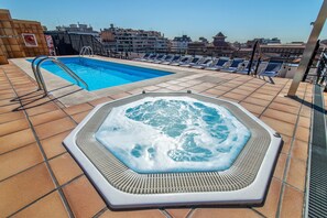 A rooftop pool area with a hot tub and lounge chairs. - Sunotel Aston (Barcelona)