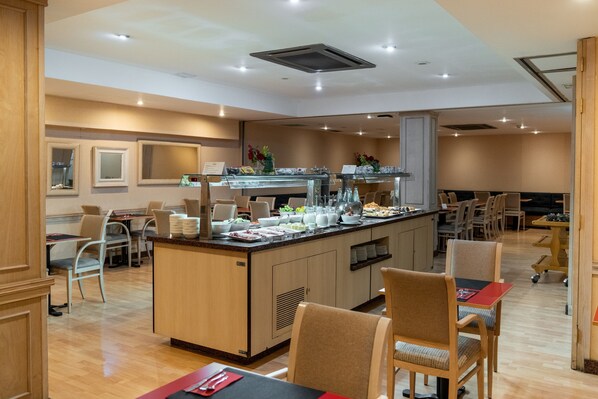 A modern dining area with a central island, multiple seating options, and a clean, well-lit environment.