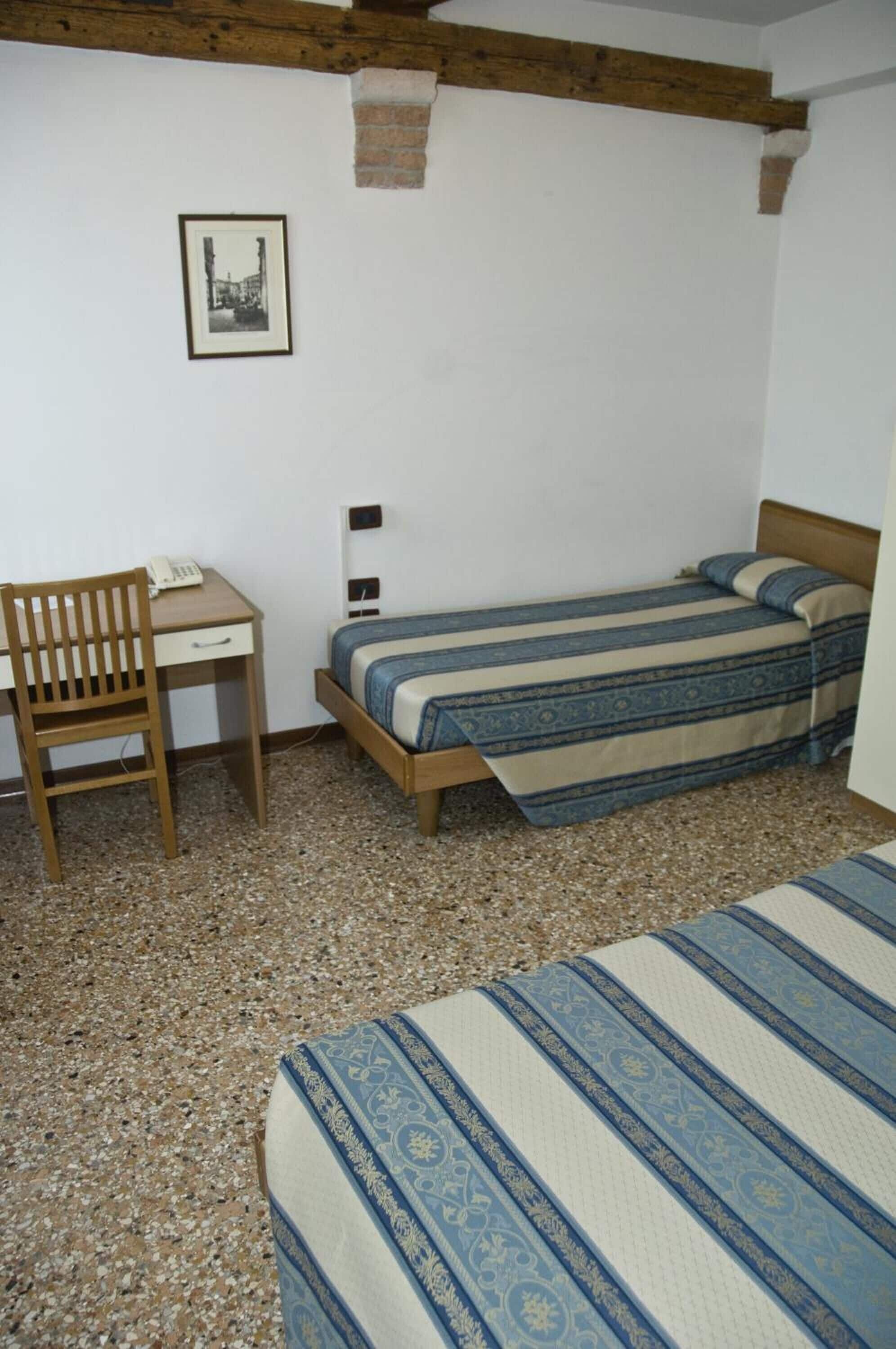 A small room with a bed, a desk, and a chair.