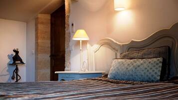A bedroom with a bed, a nightstand, a lamp, and a decorative item on the wall.