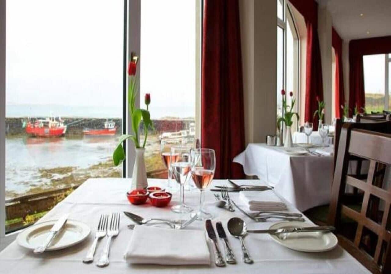 A table set for dining with a view of boats on water.
