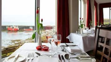 A table set for dining with a view of boats on water.