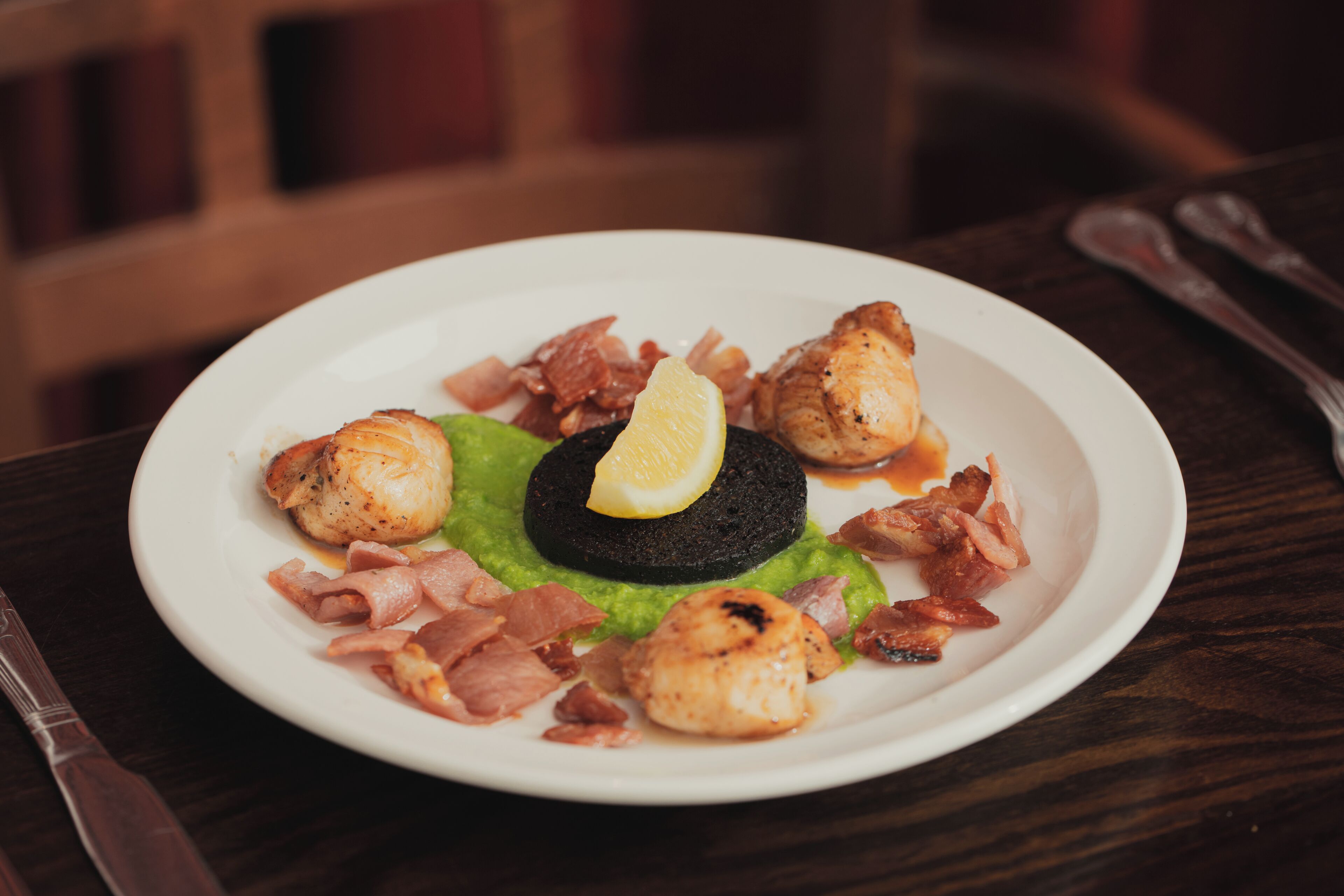 Um prato com bolo preto, limão e bacon.