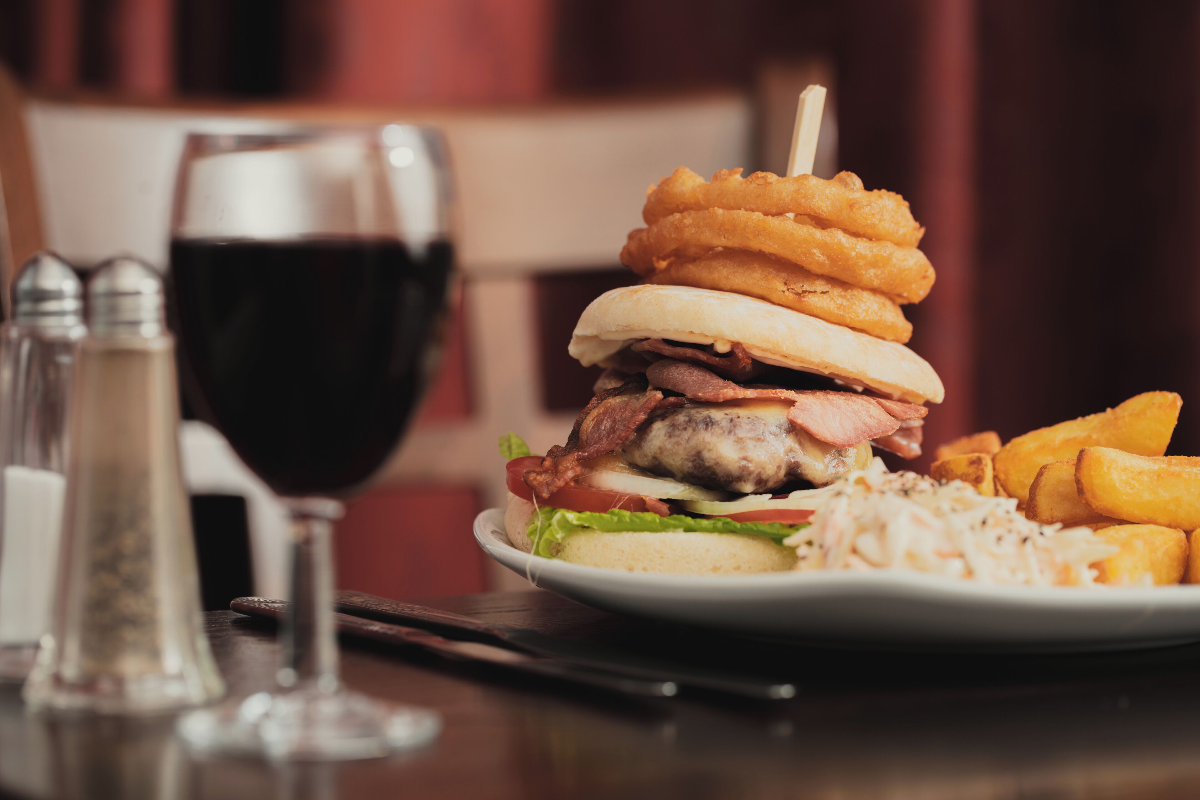 A burger with onion rings and fries on a plate.