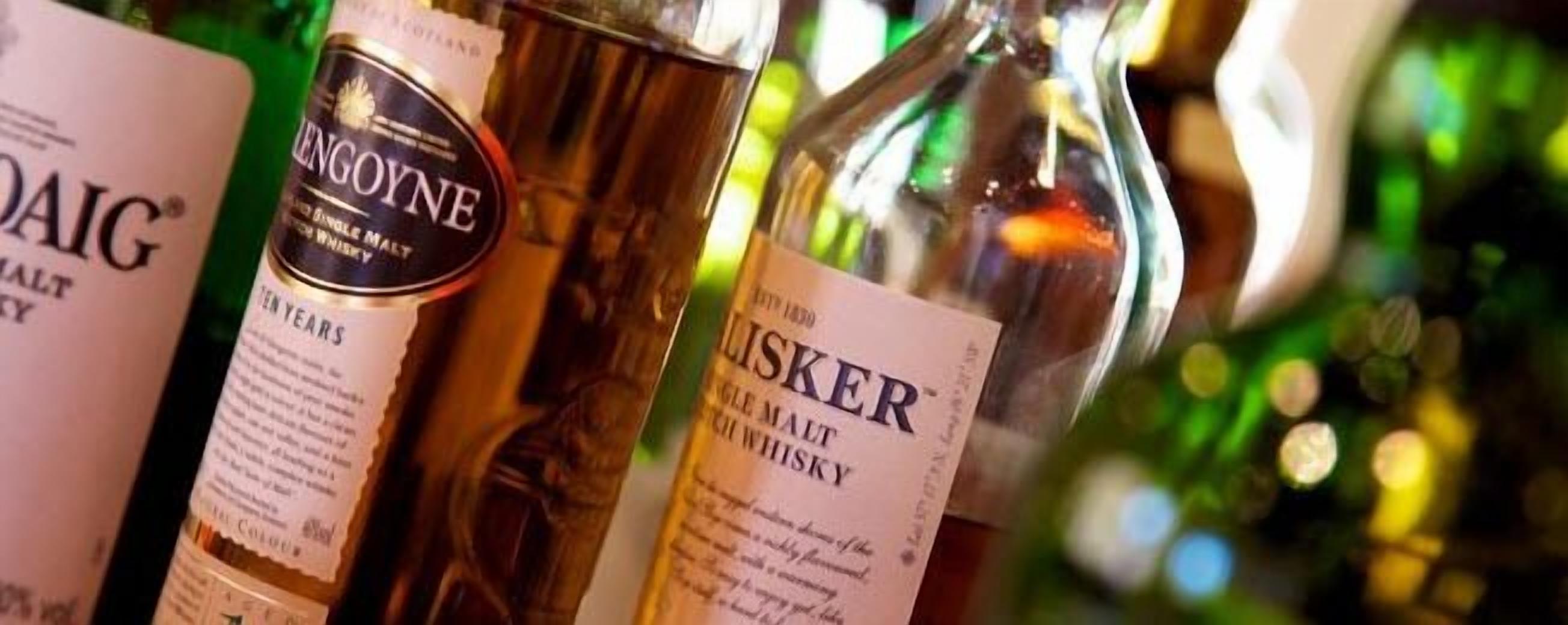 Whiskyflaschen mit sichtbaren Etiketten, die Marken und Sorten zeigen.