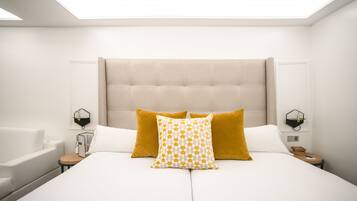 A modern bedroom with a large bed, two nightstands, a wall-mounted lamp, and a built-in headboard.