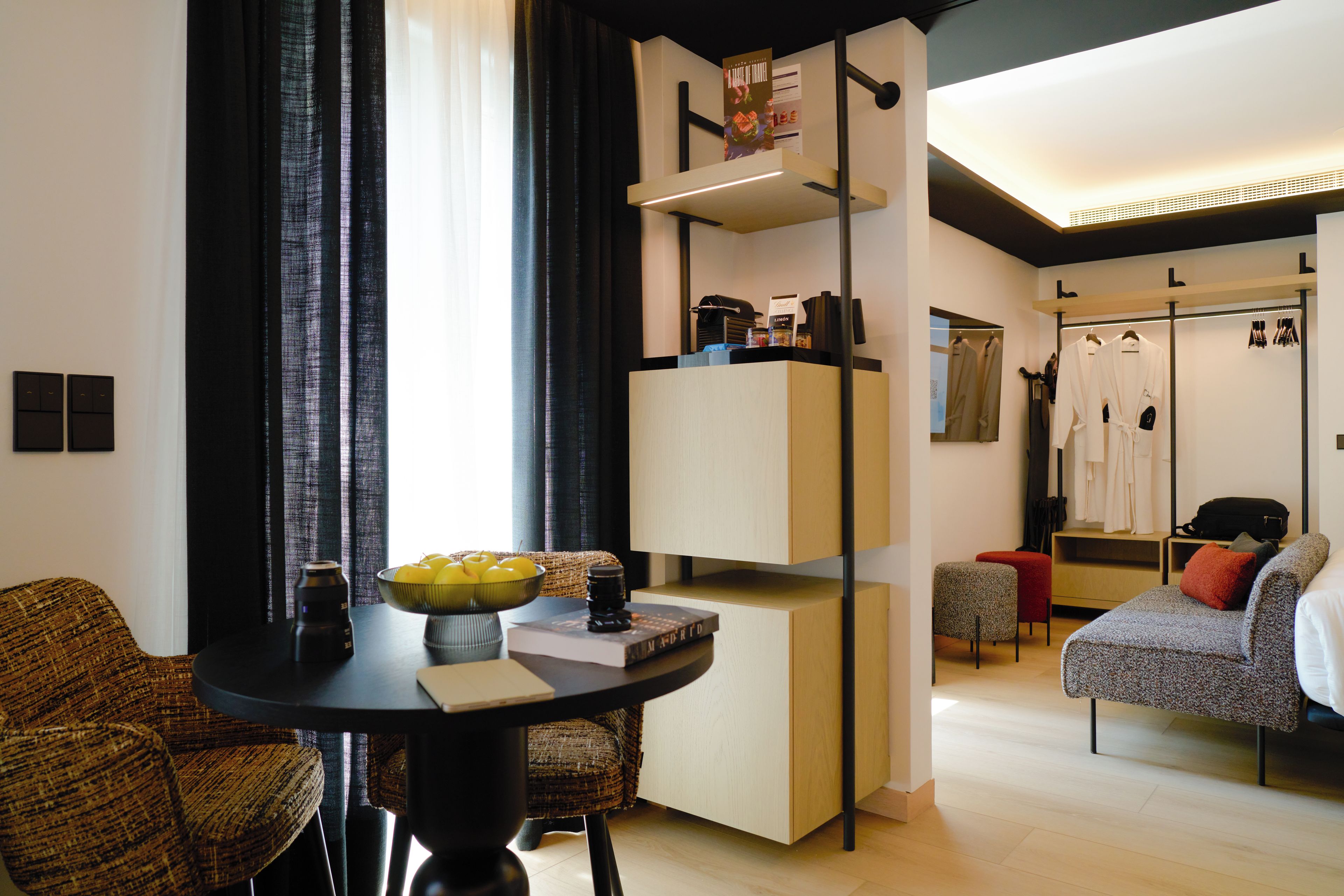 Una habitación de hotel moderna con comedor, armario y zona de estar.