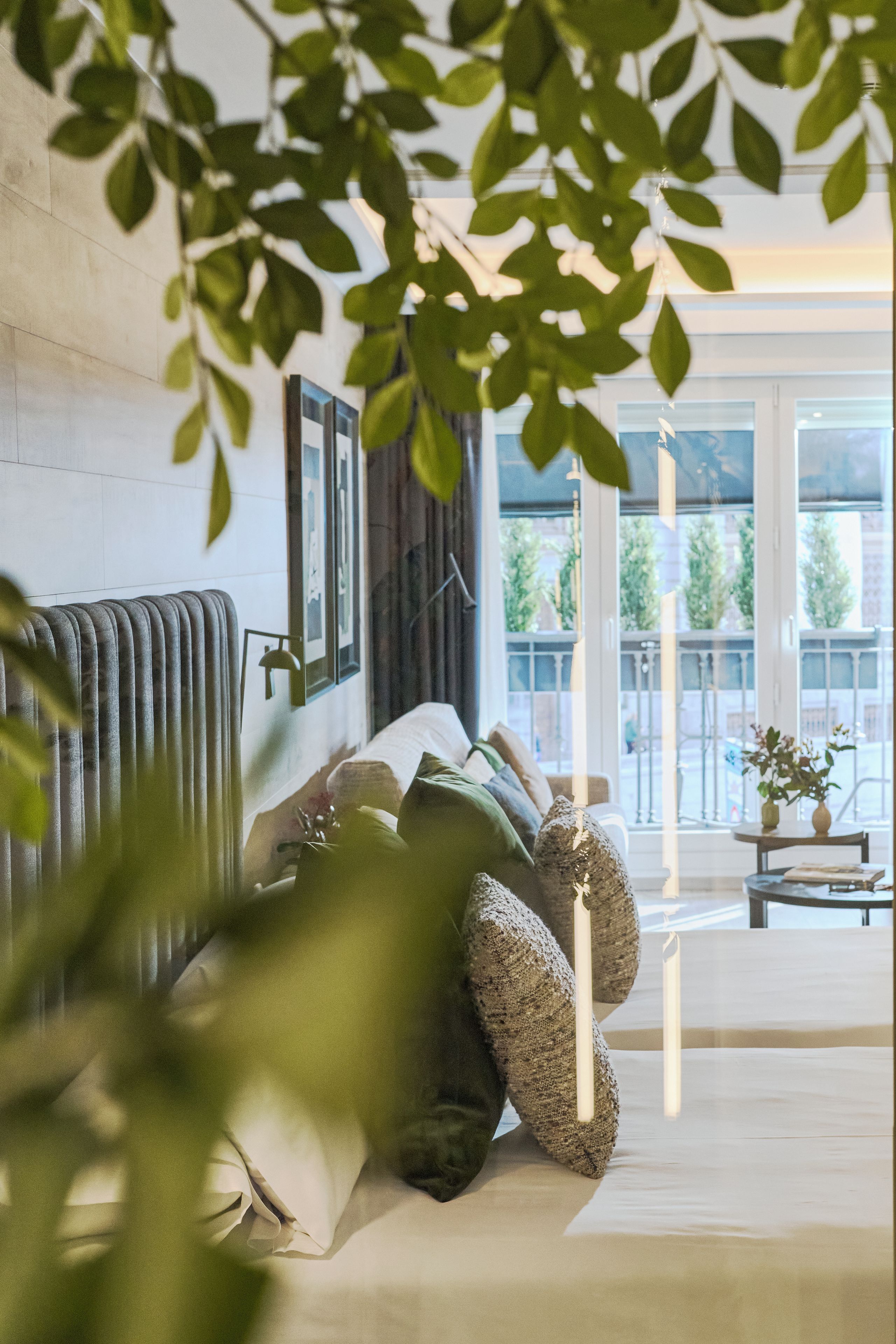 A modern living room with a sofa, a radiator, and a view of the outside.