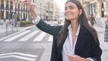 Una persona parada en una calle de la ciudad, con edificios al fondo.