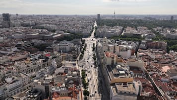 Une vue urbaine avec un large boulevard bordé de bâtiments historiques et, au loin, une tour moderne.