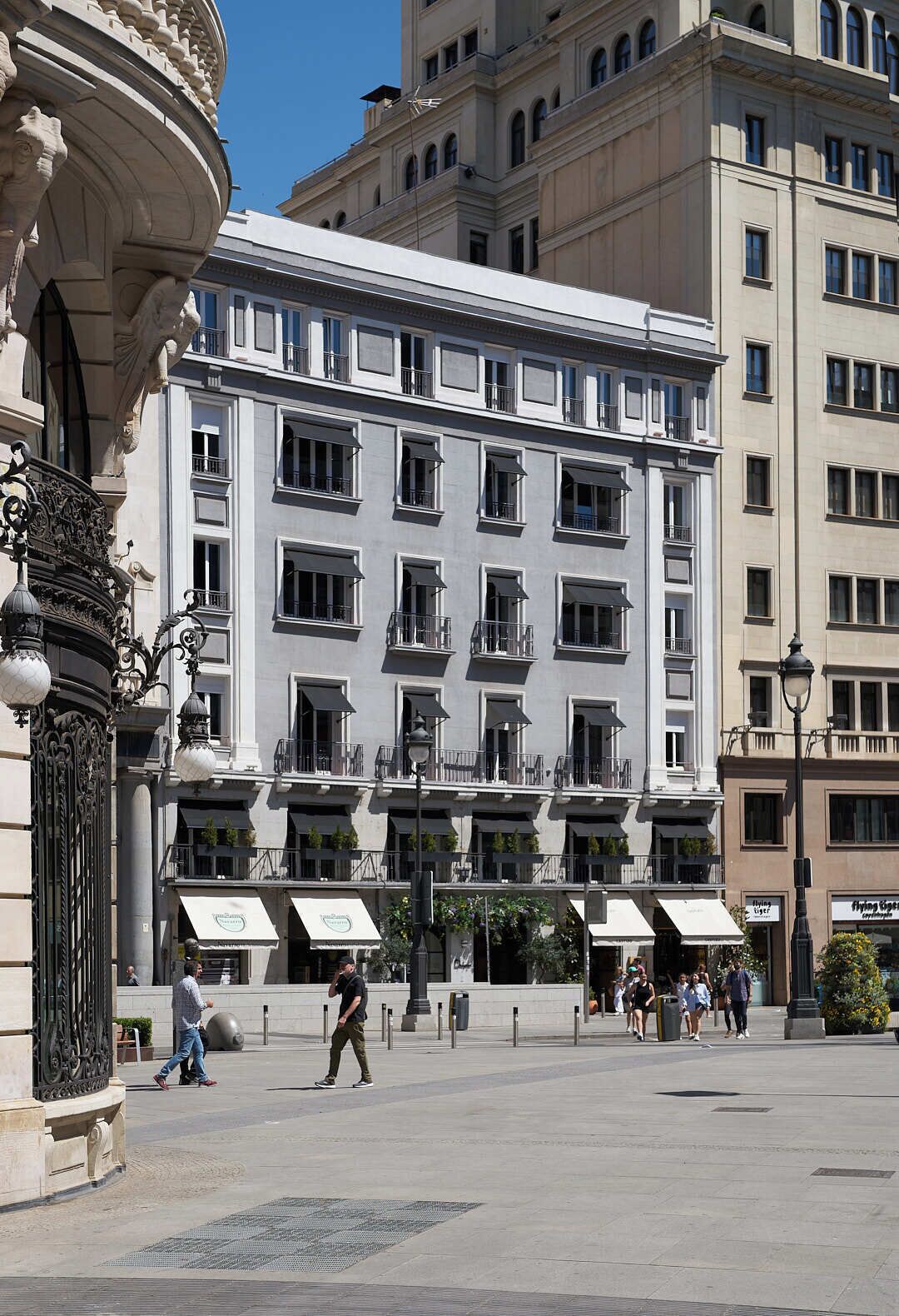 Un edificio de varios pisos con arquitectura clásica, que cuenta con balcones y ventanas amplias.