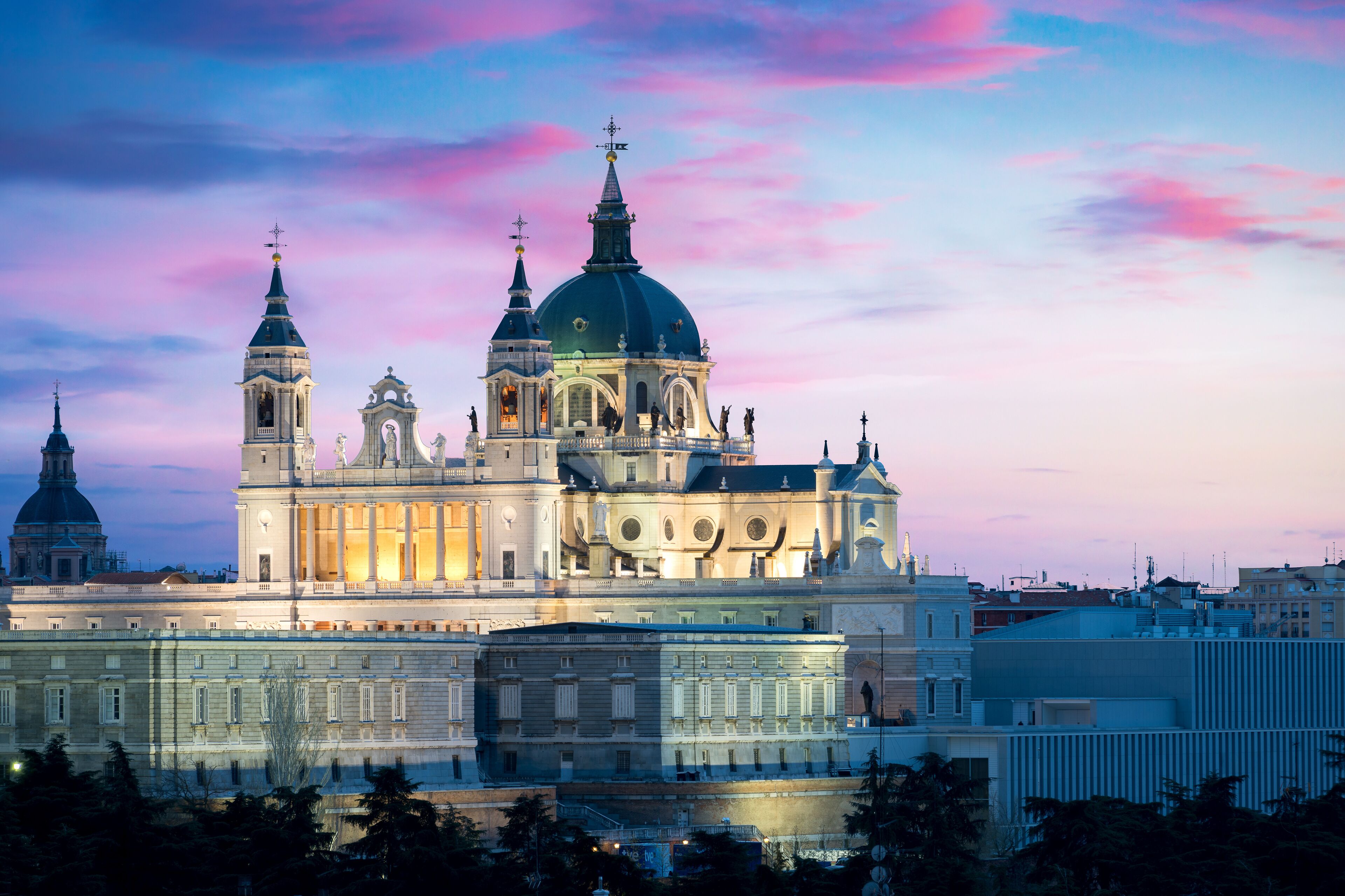 A historic building with multiple domes and towers, likely a cathedral or large church, with a reflective facade and a prominent dome.