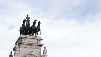 A statue of a man on horseback atop a classical building with ornate architectural details.
