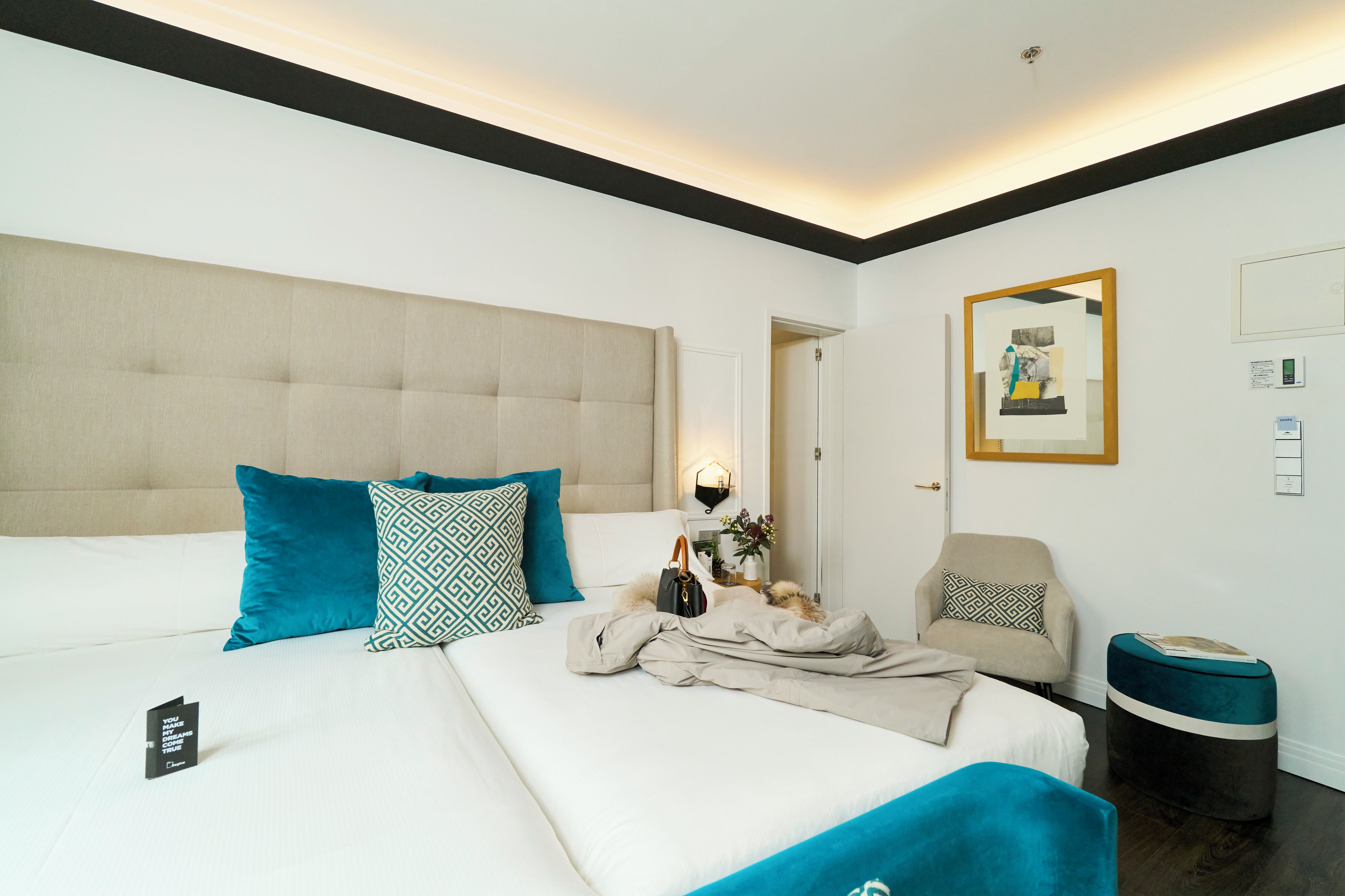 Una habitación de hotel con una cama grande, una silla, una mesita y un cesto de basura.