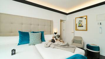Una habitación de hotel con una cama grande, una silla, una mesita y un cesto de basura.
