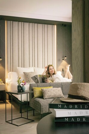 A modern living room with a sofa, a coffee table, and a bookshelf. - Hotel Regina (Madrid)