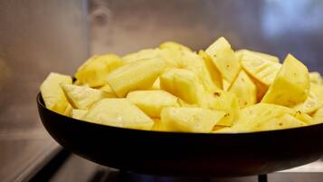 A bowl of diced yellow fruit, likely pineapple, on a stove.