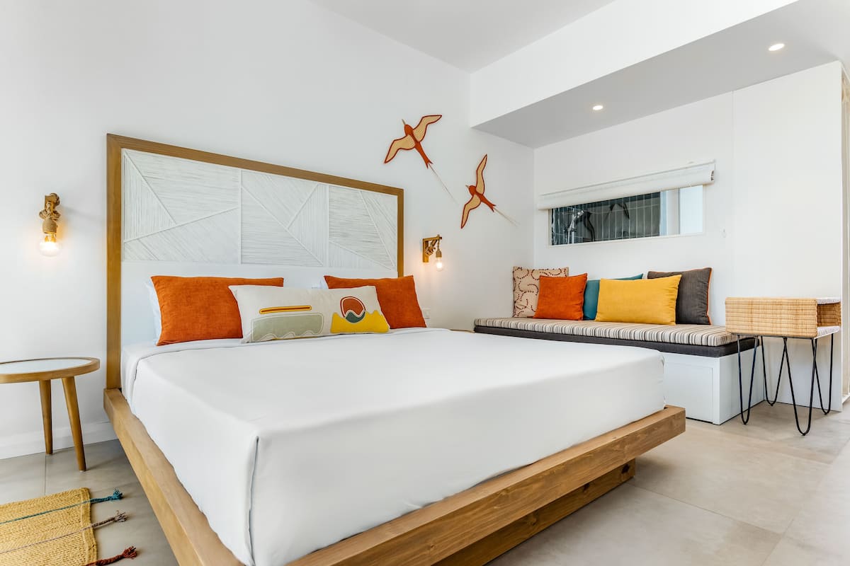 Un dormitorio moderno con una cama grande, un sofá y una pequeña mesa.