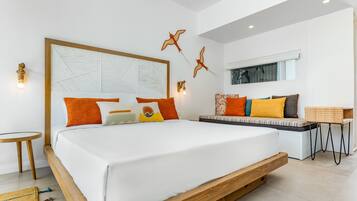 Un dormitorio moderno con una cama grande, un sofá y una pequeña mesa.