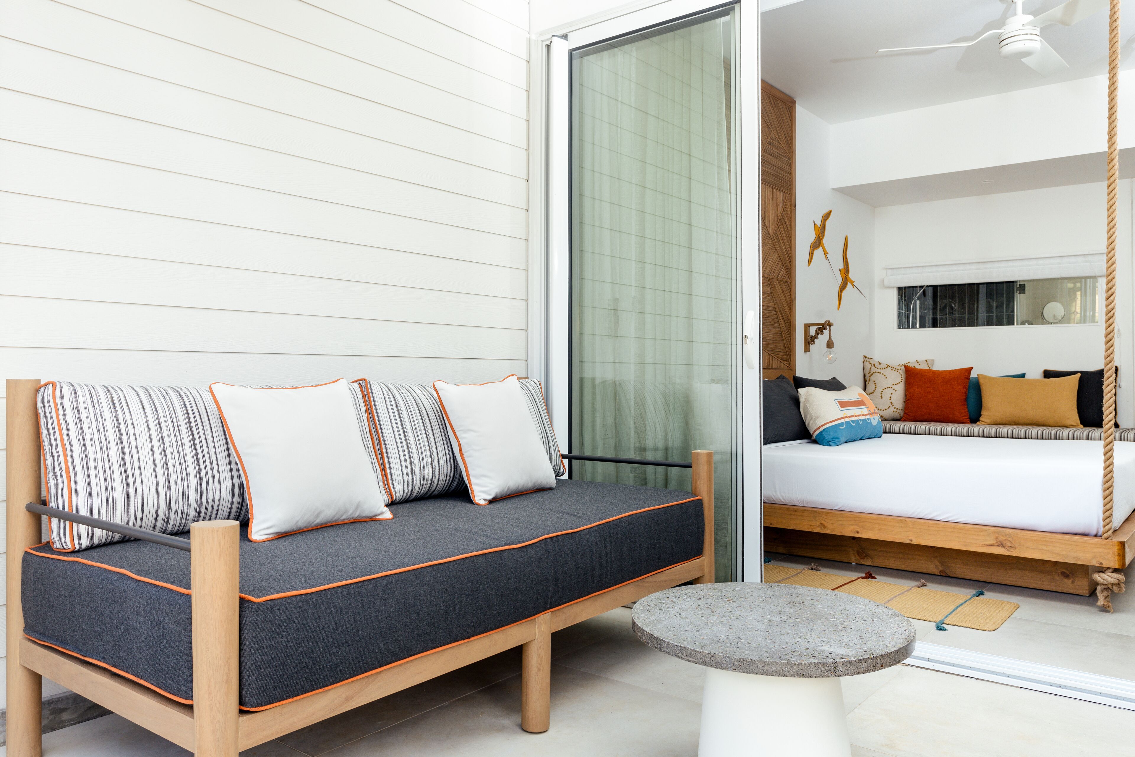 Ein modernes Zimmer mit einer Holz-Couch und einem Bett mit Hängemattenfunktion.