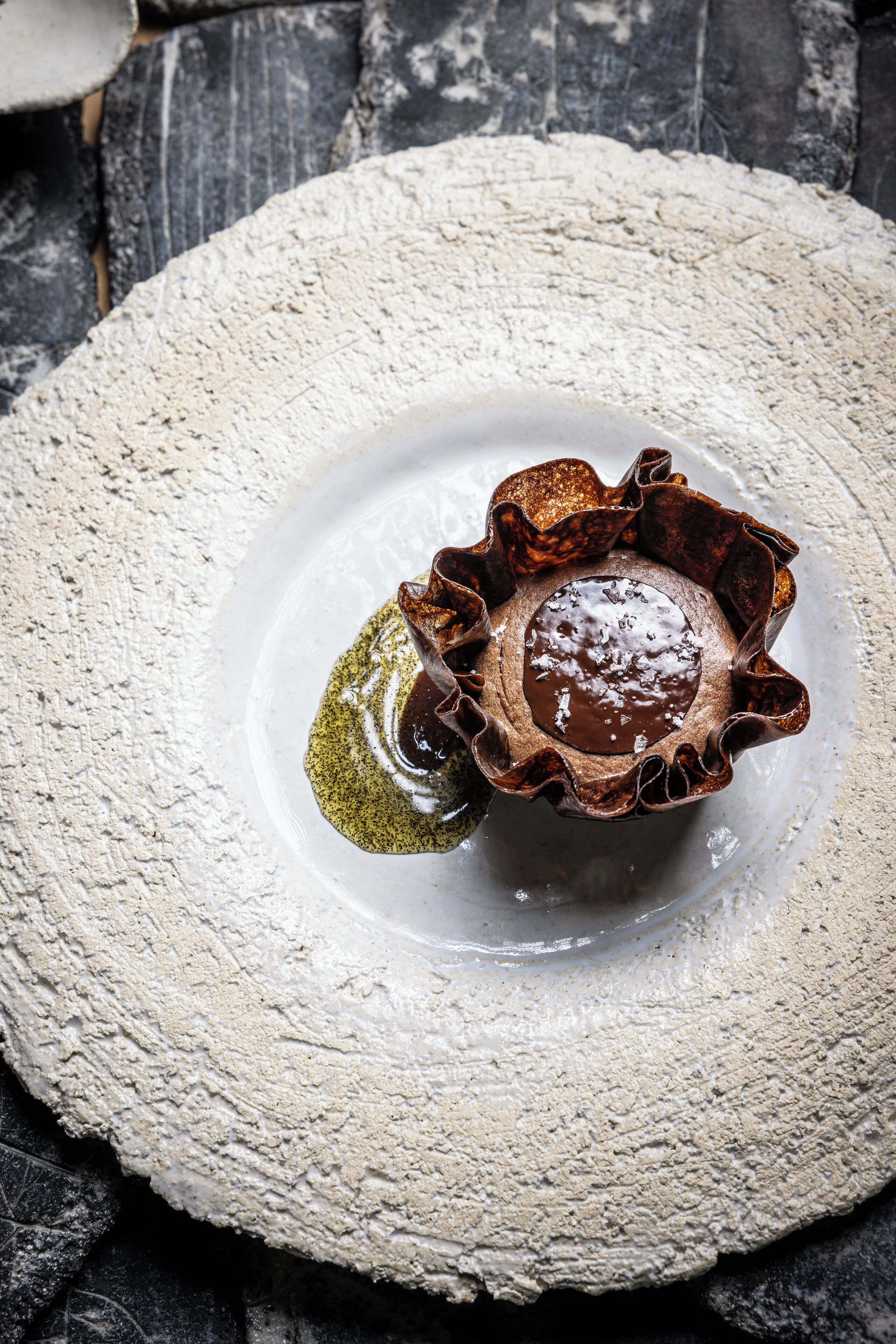 Ein Dessert in einer rustikalen, strukturierten Schüssel auf einer Holzunterlage.
