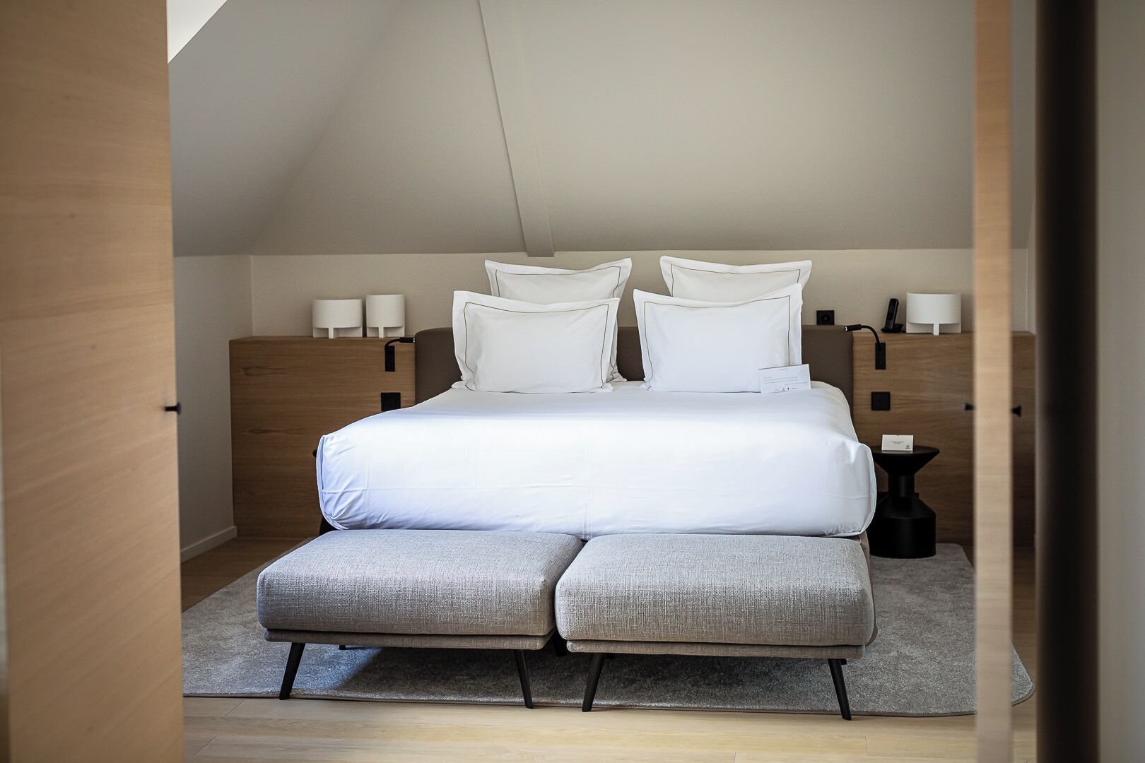 Ein modernes Schlafzimmer mit einem großen Bett, zwei Nachttischen und einer kleinen Nachttischlampe.