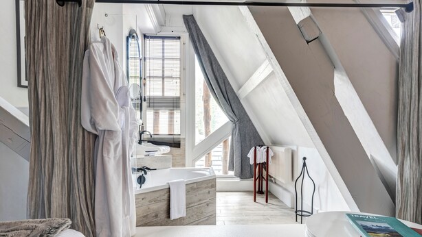A modern bathroom with a freestanding bathtub, a large mirror, and a window with blinds. - Château des Avenieres (Cruseilles)