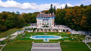 A large, historic building with a central courtyard, multiple balconies, and a swimming pool. - Château des Avenieres (Cruseilles)