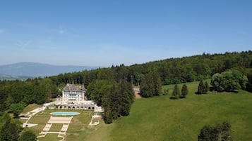 A large estate with a swimming pool, tennis courts, and a landscaped garden.