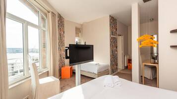 Una habitación de hotel con cama, televisión, escritorio y silla.