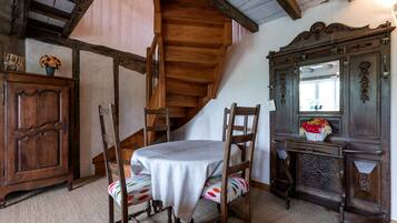 Un comedor de madera con una mesa, sillas, un armario de madera y una escalera.