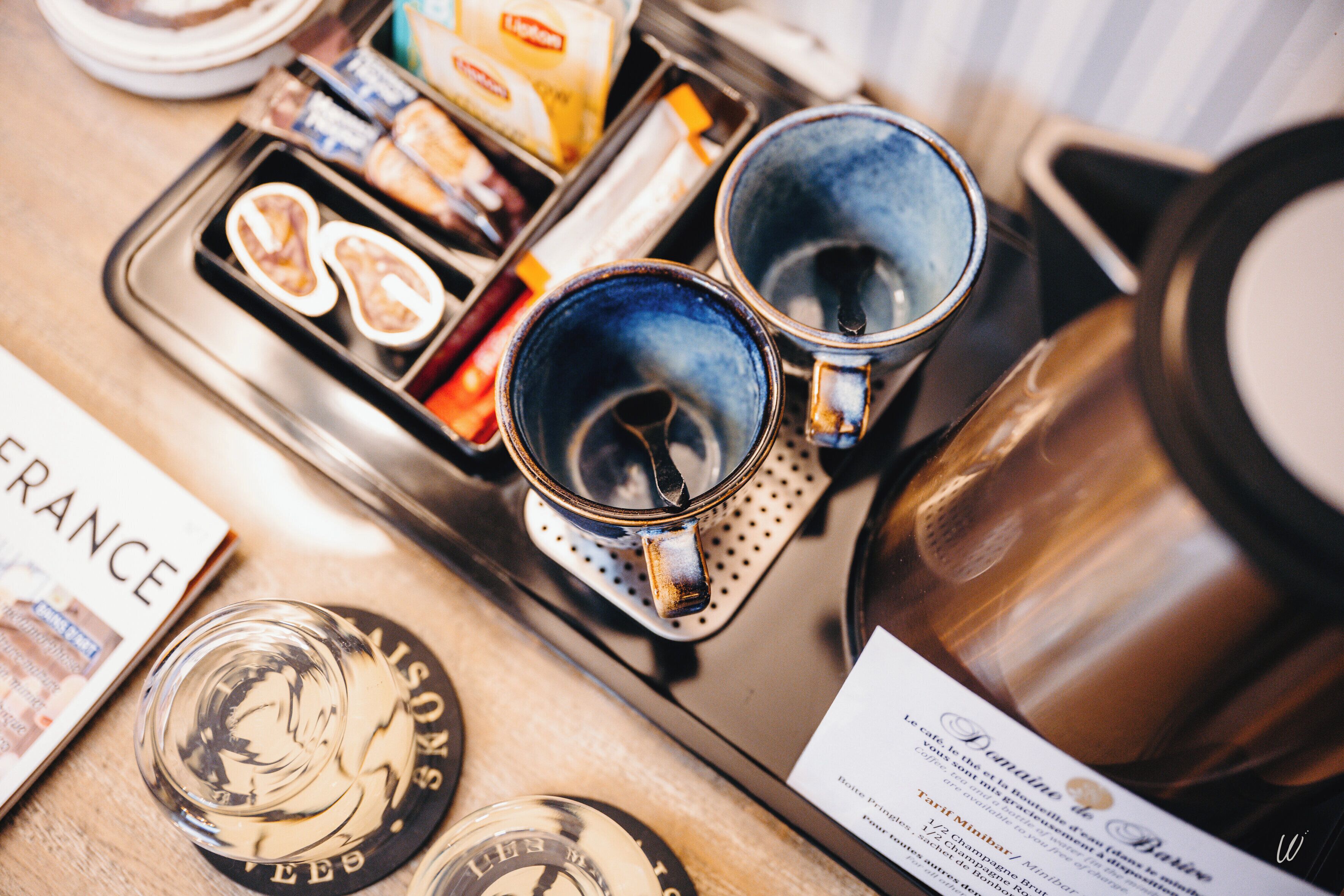 A tray with two cups, a teapot, and a menu.