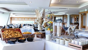 A buffet area with various food items, including pastries, fruits, and beverages.